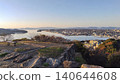 A spectacular panoramic view of the calm waters of Lake Nakaumi and the cityscape stretching out on the opposite shore, as seen from the castle tower base of Yonago Castle. 140644608