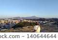 A female tourist's back as she gazes upon the magnificent view of Mt. Daisen and the city from the castle tower base of Yonago Castle ruins. 140644644