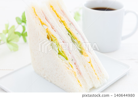 A delicious ham, egg, and lettuce sandwich and coffee. 140644980