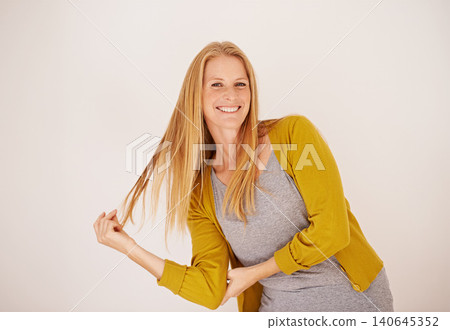 Smile, fashion and portrait of woman in studio with casual, trendy and cool outfit with confidence. Happy, attractive and female person playing with hair for cardigan style by white background. Smile, fashion and portrait of woman in studio with casual, trendy and cool outfit with confidence. Happy, attractive and female person playing with hair for cardigan style by white background. 140645352