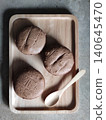 Three Whole Grain Bread Buns on Wooden Tray with Spoon in Minimal Loft Style Cafe Setting for Rustic Bakery Food Presentation 140645470