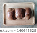 Overbaked Whole Wheat Bread Loaf with Burnt Crust Placed on Wooden Tray Showing Low Grade Bakery Product Suitable for Discount Sale or Reduced Price 140645628