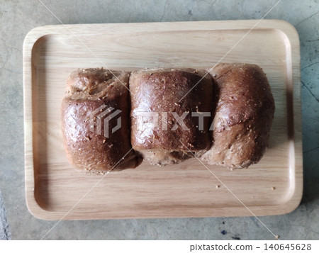 Overbaked Whole Wheat Bread Loaf with Burnt Crust Placed on Wooden Tray Showing Low Grade Bakery Product Suitable for Discount Sale or Reduced Price Overbaked Whole Wheat Bread Loaf with Burnt Crust Placed on Wooden Tray Showing Low Grade Bakery Product Suitable for Discount Sale or Reduced Price 140645628