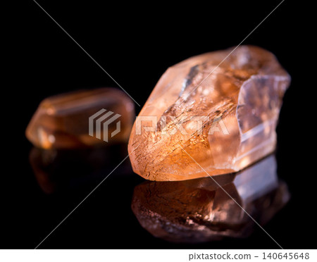 Orange stone, jewel and crystal in studio with isolated black background for natural resource, shine and sparkle for luxury. gemstone, rock and reflection in closeup for citrine, glow and mineral Orange stone, jewel and crystal in studio with isolated black background for natural resource, shine and sparkle for luxury. gemstone, rock and reflection in closeup for citrine, glow and mineral 140645648