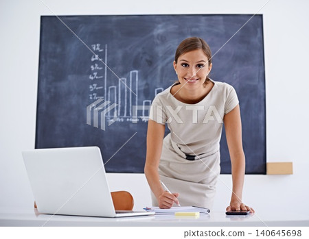 Teacher, woman and smile for marking in classroom with smile for planning, exam or review at desk. Person, computer and laptop for writing feedback, results or test for education, learning or school Teacher, woman and smile for marking in classroom with smile for planning, exam or review at desk. Person, computer and laptop for writing feedback, results or test for education, learning or school 140645698