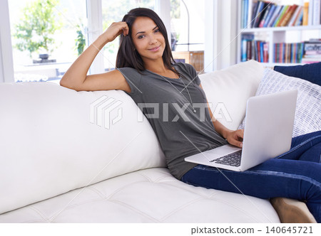 Portrait, woman and laptop with smile in lounge, working or relaxing or break on couch. Female person, watching or typing in computer, technology and connectivity for results in living room or house Portrait, woman and laptop with smile in lounge, working or relaxing or break on couch. Female person, watching or typing in computer, technology and connectivity for results in living room or house 140645721