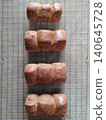 Freshly Baked Warm Chocolate Bun Bread Loaves Arranged on Cooling Rack Showing Soft Texture and Golden Brown Crust for Bakery Presentation 140645728