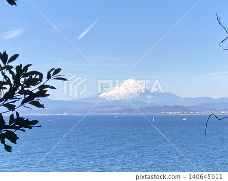 A breathtaking view of the beautiful Mt. Fuji towering beyond the blue sea and sky. 140645911