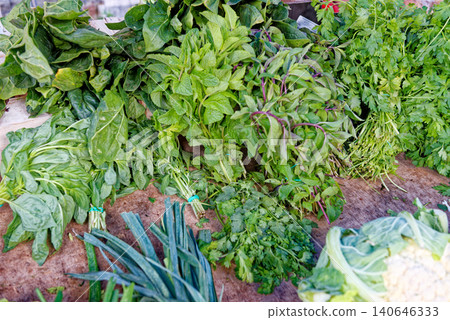 Vibrant display of fresh, leafy green herbs and vegetables Vibrant display of fresh, leafy green herbs and vegetables 140646333