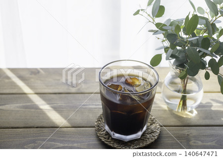 A refreshing summer table photo featuring iced coffee and eucalyptus. A refreshing summer table photo featuring iced coffee and eucalyptus. 140647471