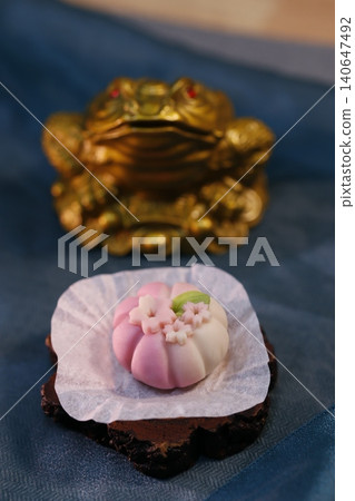Delicate Pastry and Ornate Golden Object on Blue Fabric Delicate Pastry and Ornate Golden Object on Blue Fabric 140647492