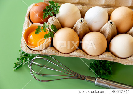 Farm fresh eggs with whisk and greens on minimal background Farm fresh eggs with whisk and greens on minimal background 140647745