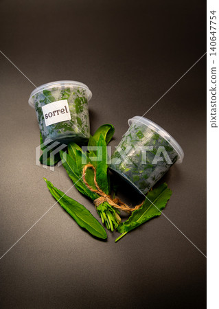 Natural organic sorrel in container with rustic dark backdrop Natural organic sorrel in container with rustic dark backdrop 140647754