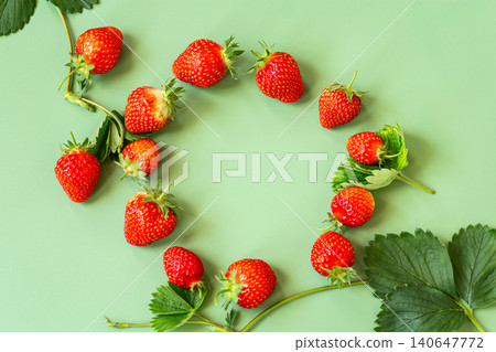 Organic garden strawberries arranged on pastel green backdrop Organic garden strawberries arranged on pastel green backdrop 140647772