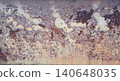 Close view of rusty metal surface with peeling paint and corrosion patterns showing orange and brown colors in natural light on a sunny day 140648035