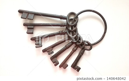 Collection of old metal keys on a ring lying on a flat surface in a bright setting during daylight Collection of old metal keys on a ring lying on a flat surface in a bright setting during daylight 140648042