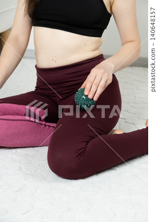 Female in sportswear using trigger point ball for leg muscle recovery Female in sportswear using trigger point ball for leg muscle recovery 140648157