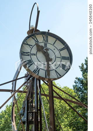 Close-up of an ancient iron clock tower on a sunny summer day Close-up of an ancient iron clock tower on a sunny summer day 140648160
