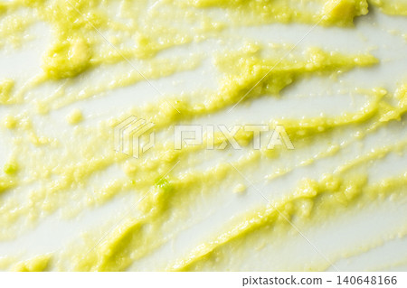 Abstract food art background with green avocado puree on white surface. Abstract food art background with green avocado puree on white surface. 140648166