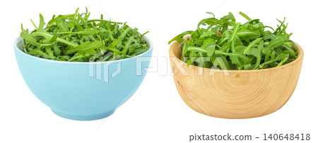 Heap of green fresh rucola or arugula leaf in ceramic and wooden bowl isolated on white background 140648418