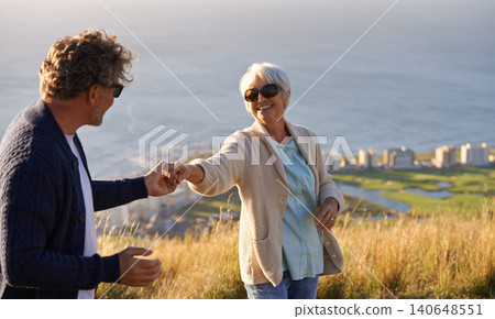Happy, vacation and couple outdoor in dance on hill or mountain in Cape Town and holding hands with love. Mature, people and embrace with kindness on holiday adventure in nature and relax together 140648551