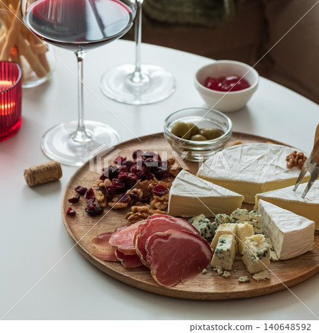 Wine and cheese board appetizers enjoying evening at home Wine and cheese board appetizers enjoying evening at home 140648592