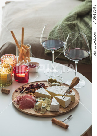 Serving cheese and charcuterie board with red wine Serving cheese and charcuterie board with red wine 140648595