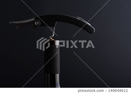 Corkscrew opening a bottle of red wine 140648612
