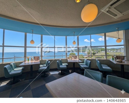 The cafe has an open, airy atmosphere with large windows offering panoramic ocean views. 140648985