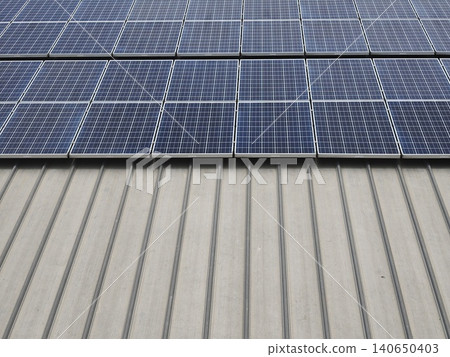 Wide Array of Solar Panels on Industrial Building Roof 140650403