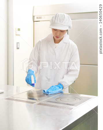 身穿白大褂的女工作人員正在擦拭表面進行清潔。 身穿白大褂的女工作人員正在擦拭表面進行清潔。 140650429