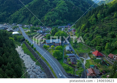 An aerial photograph overlooking the Yuki Onsen hot spring resort area in Hiroshima Prefecture, with the lush green mountains in the background. An aerial photograph overlooking the Yuki Onsen hot spring resort area in Hiroshima Prefecture, with the lush green mountains in the background. 140650623