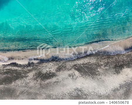 Serene ocean with pebbles. Gentle sea waves over mixed sandy and rocky shoreline. Soothing aerial view of tranquil ocean meeting pebble beach with sunlight ripples Serene ocean with pebbles. Gentle sea waves over mixed sandy and rocky shoreline. Soothing aerial view of tranquil ocean meeting pebble beach with sunlight ripples 140650678