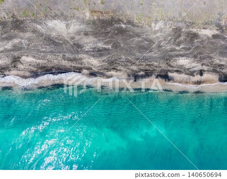 Abstract shoreline ribbon foam aerial composition, delicate line of white surf dividing turquoise sea from coarse pebble beach, minimalist mood suited for design and editorial use Abstract shoreline ribbon foam aerial composition, delicate line of white surf dividing turquoise sea from coarse pebble beach, minimalist mood suited for design and editorial use 140650694