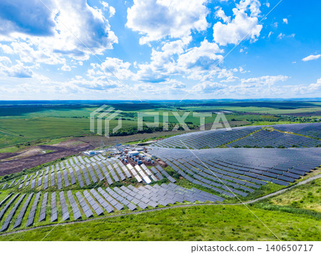 Solar panels cover large area in rural landscape with blue sky and scattered clouds during the daytime Solar panels cover large area in rural landscape with blue sky and scattered clouds during the daytime 140650717