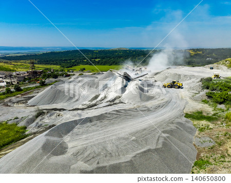 Granite quarry site with machines and piles of stone dust during a sunny day in an outdoor location Granite quarry site with machines and piles of stone dust during a sunny day in an outdoor location 140650800