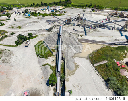 Granite quarry site with machinery and stockpiles seen from above during daytime operations Granite quarry site with machinery and stockpiles seen from above during daytime operations 140650846