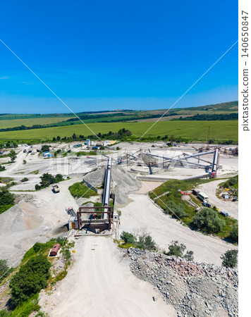 Large granite quarry site with machinery and operation in progress during bright sunny day Large granite quarry site with machinery and operation in progress during bright sunny day 140650847