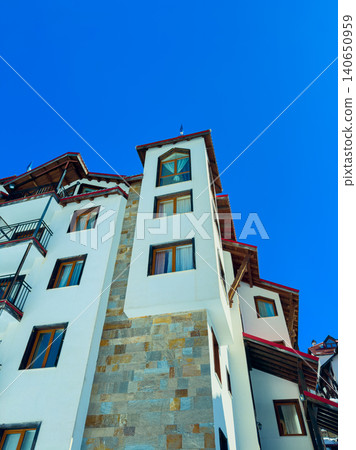 Tall building under clear blue sky with many windows and distinct architecture located in scenic area, showing off its design and structure during bright day Tall building under clear blue sky with many windows and distinct architecture located in scenic area, showing off its design and structure during bright day 140650959