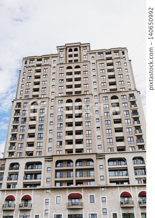 Elegant cityscape imagery. Stylish residential building scene. Refined urban architecture with charming details. Graceful beige highrise featuring decorative balconies and arches 140650992