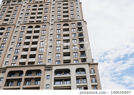 Skyscraper with depth. Vertical residential structure showcasing perspective and design. Tall apartment block emphasizing depth and architectural features in city planning Skyscraper with depth. Vertical residential structure showcasing perspective and design. Tall apartment block emphasizing depth and architectural features in city planning 140650997