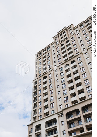 Elegant building with neutral colors. Sleek skyscraper under clear blue sky with soft hues. Contemporary tall structure characterized by uncluttered lines and muted tones Elegant building with neutral colors. Sleek skyscraper under clear blue sky with soft hues. Contemporary tall structure characterized by uncluttered lines and muted tones 140650999