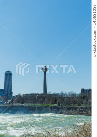 View of Niagara Falls with Skylon Tower and surrounding buildings on a clear day 140651059