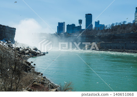 Visitors enjoy the view of Niagara Falls with city skyline on a bright sunny day in spring Visitors enjoy the view of Niagara Falls with city skyline on a bright sunny day in spring 140651068