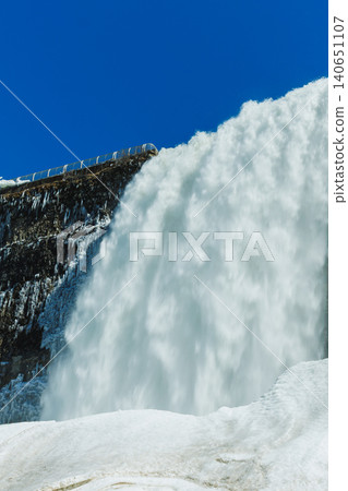 Niagara Falls during winter with frozen water and mist in the air on a clear day Niagara Falls during winter with frozen water and mist in the air on a clear day 140651107