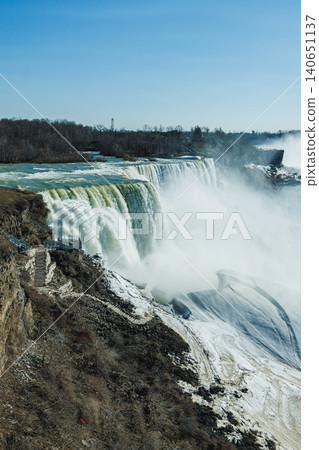 Water flows over Niagara Falls in early spring, showcasing the natural beauty and power of the waterfalls on a clear day Water flows over Niagara Falls in early spring, showcasing the natural beauty and power of the waterfalls on a clear day 140651137