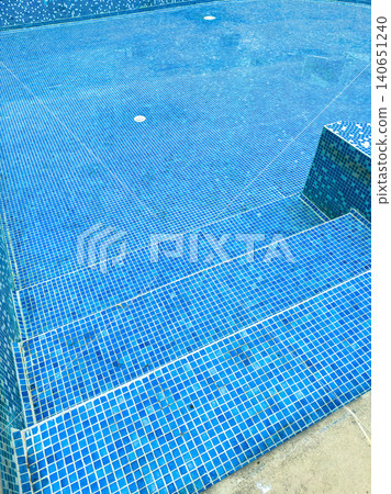 Swimming pool area with blue tiles and steps leading into water at a leisure location during midday Swimming pool area with blue tiles and steps leading into water at a leisure location during midday 140651240