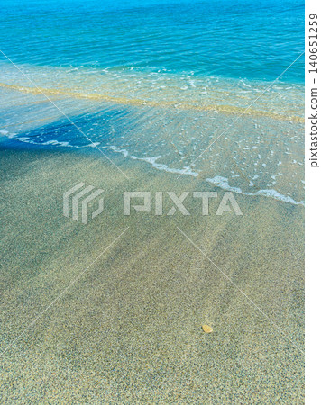 Warm sand meets clear water on a beach under bright sunlight in a coastal area during the afternoon hours Warm sand meets clear water on a beach under bright sunlight in a coastal area during the afternoon hours 140651259