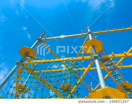 Brightly colored climbing structure under a clear sky in an outdoor play area with children exploring and having fun together Brightly colored climbing structure under a clear sky in an outdoor play area with children exploring and having fun together 140651267
