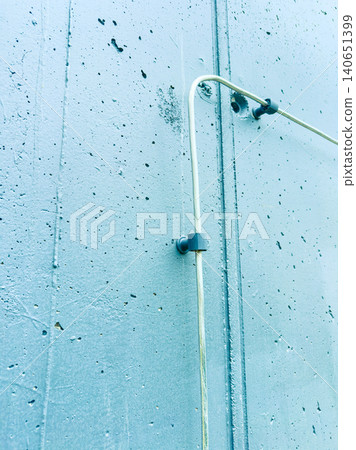 Wall with metal pipe and bracket showing textures and structures in an urban setting during daylight Wall with metal pipe and bracket showing textures and structures in an urban setting during daylight 140651399